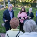 Senior Couple Walking Through Sand Dunes On Winter Beach Smiling